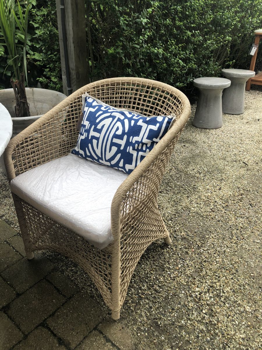 The image depicts an outdoor natural twisted faux wicker arm chair with an Alsek white fabric seat cushion placed on a paved