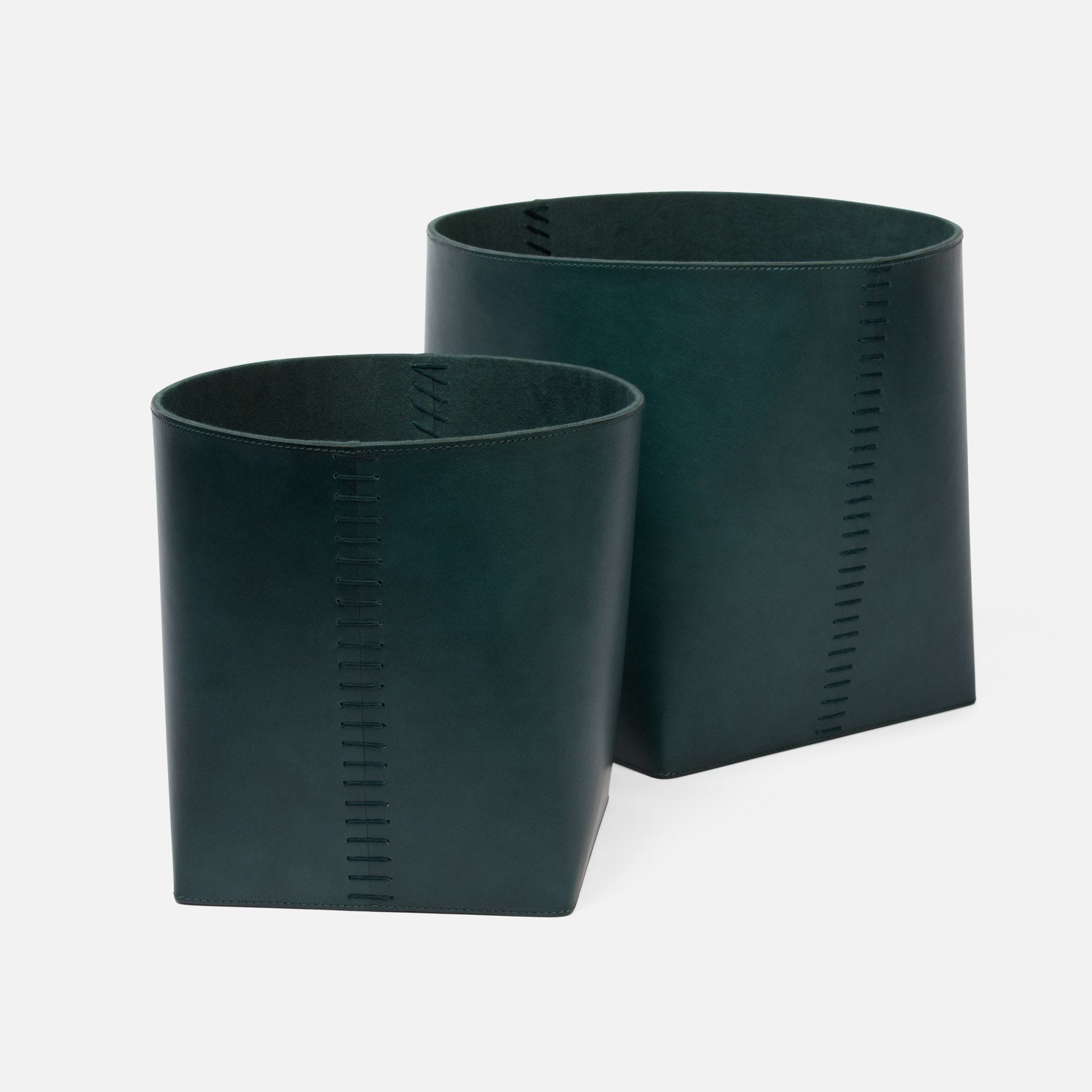 The image displays a pair of dark leather baskets with stitched detailing presented in a clean and simple manner against a plain