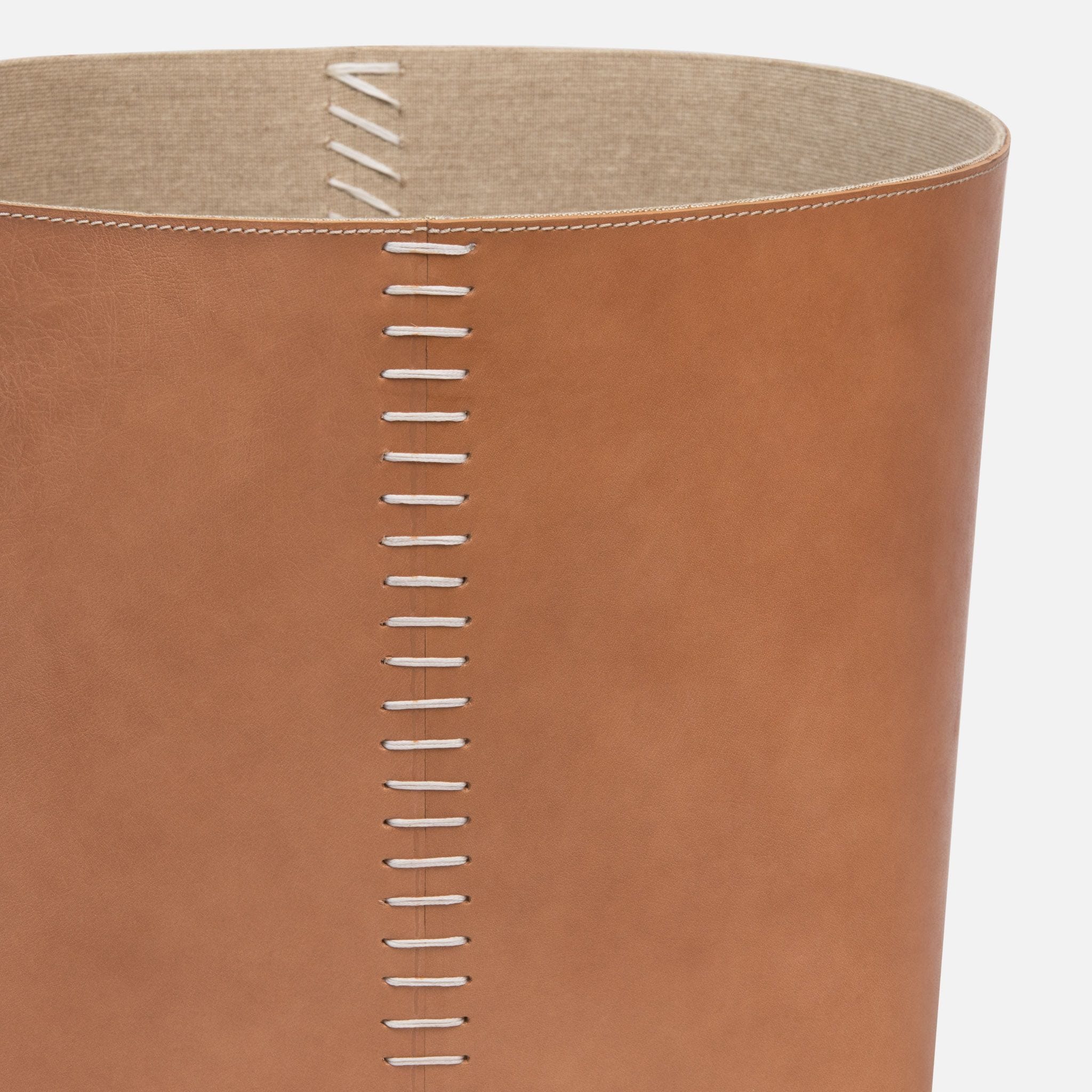 The image displays two brown leather baskets with stitched detail which appear to be a part of a set They are shown