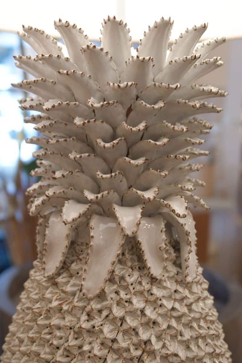 A large white pineapple table lamp with intricate details, sitting on a surface and ready to be purchased.