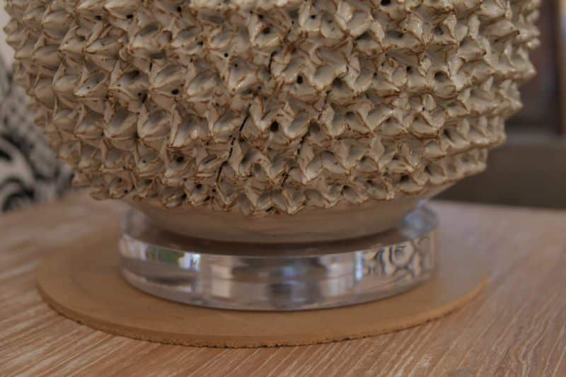 Large white pineapple table lamp with a silver base, set against a beige background.