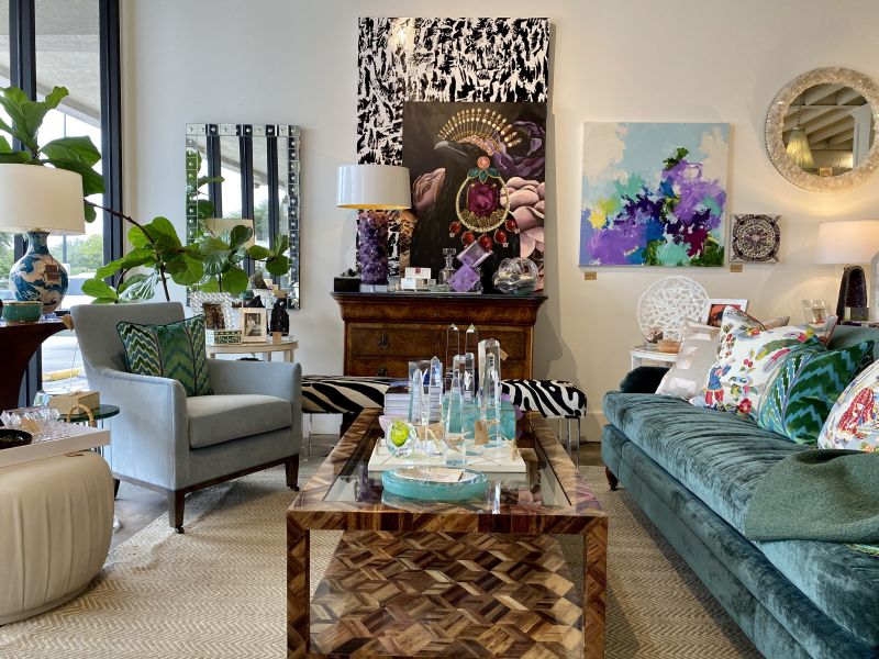 Living room with colorful decor, including a couch, coffee table, chair, and framed artwork on the wall.