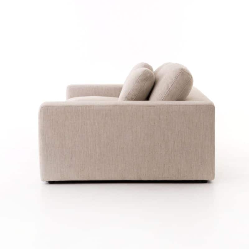 Modern beige upholstered sofa with two cushions, one at each end of a long seat and back cushion.