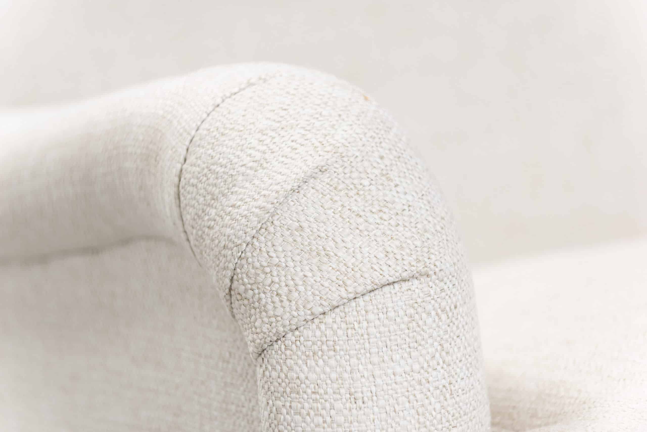 Close-up of English arm sofa in alabaster with dark brown legs and nail trim.