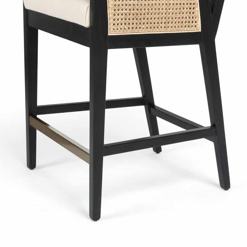 A black and gold wicker bar stool with a neutral linen blend seat.