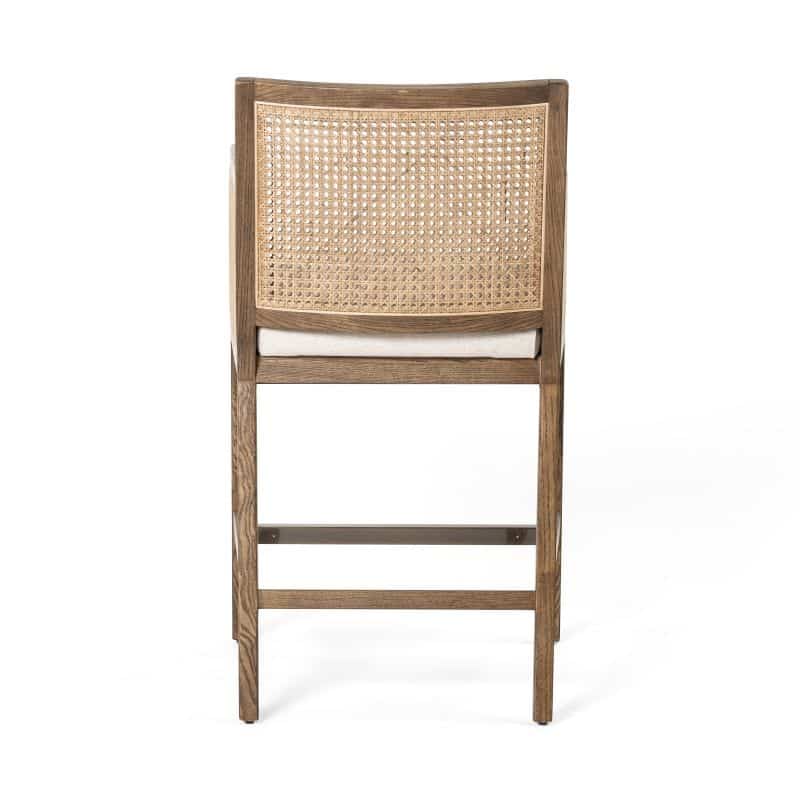 A close-up image of a stylish cane counter stool with a wicker seat and backrest.