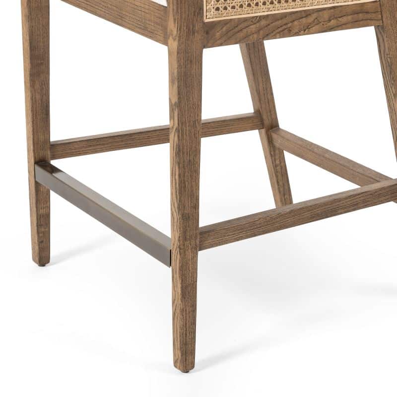 Cane counter stool with brushed ebony finish and neutral linen blend seat.