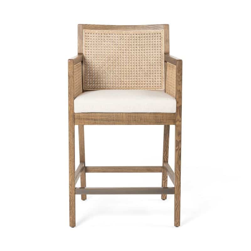 Cane counter stool with neutral fabric seat and brushed ebony or toasted wood finish.