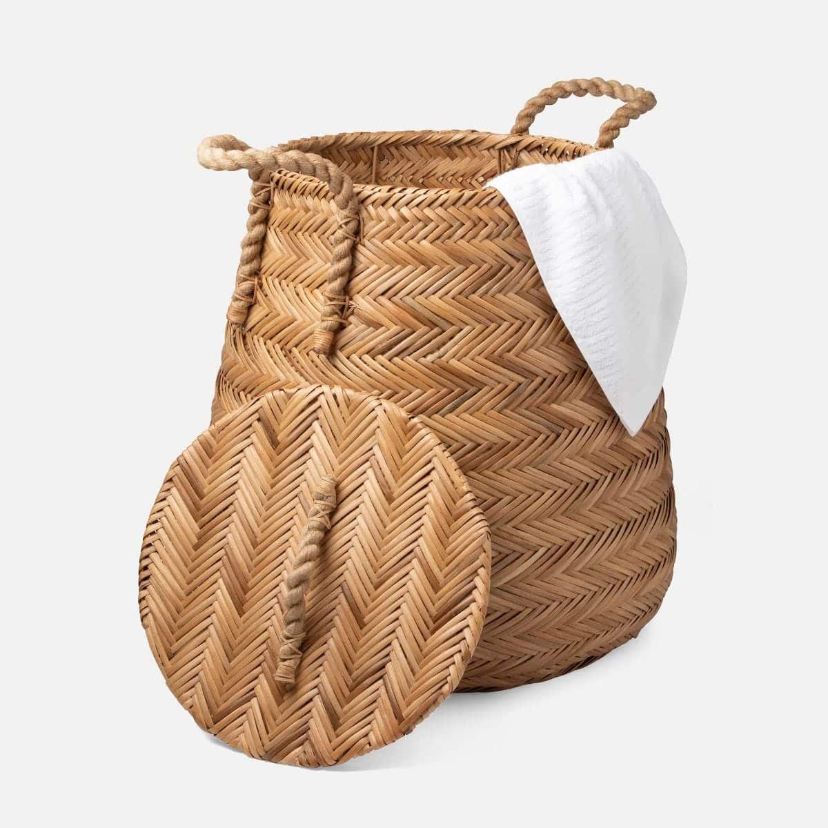 Woven chevron rattan hamper basket with side and top handles.