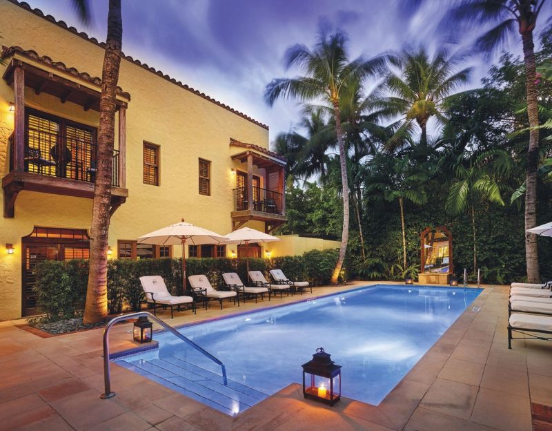 Poolside patio with pool and lounge chairs at Brazilian Court hotel.