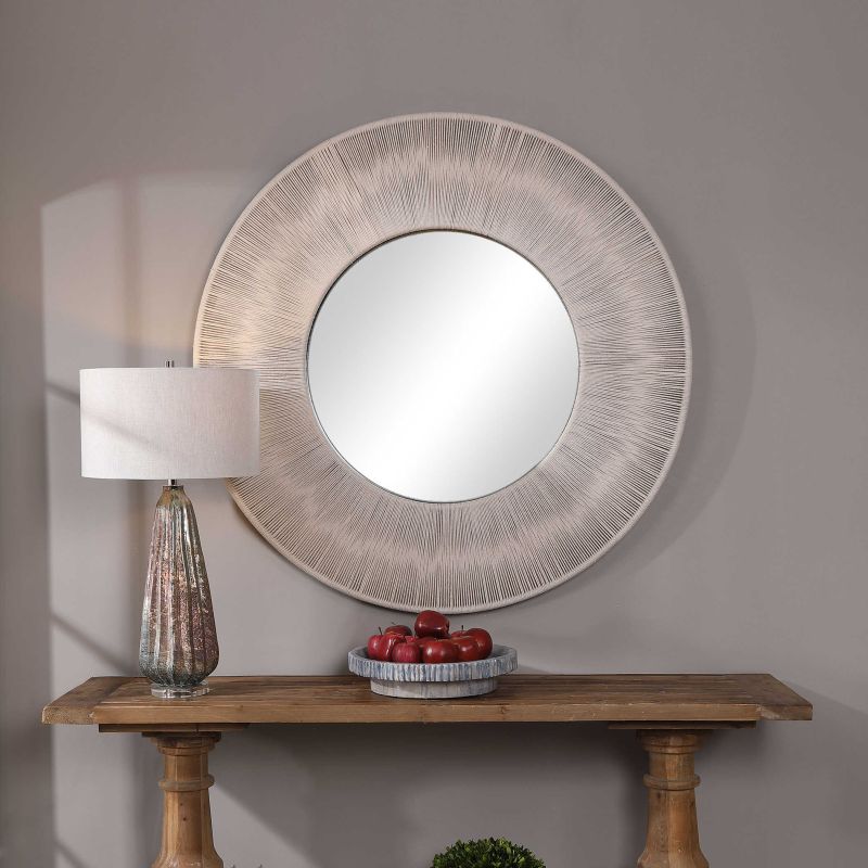 Nautical round mirror with rope frame on wall.