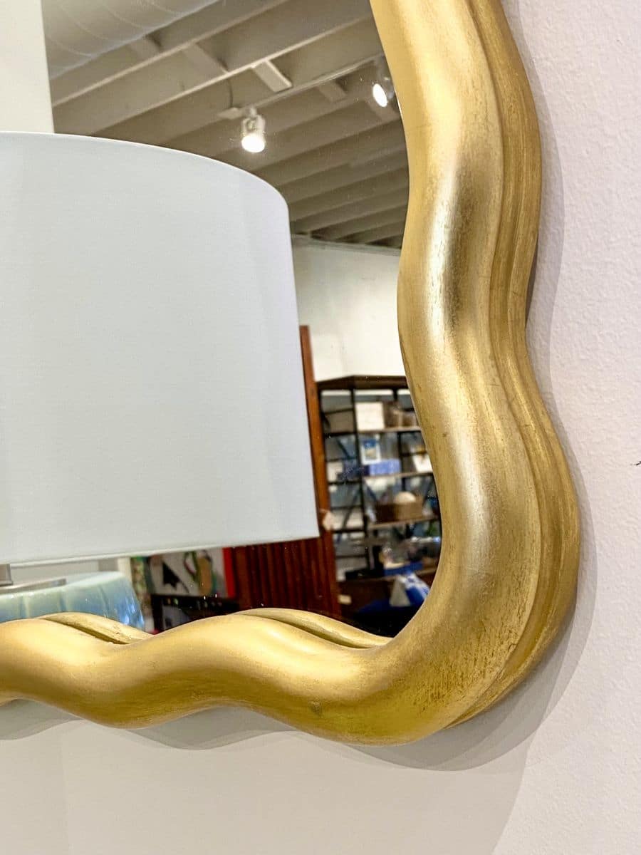 Antique gold leaf scalloped mirror on display in store.