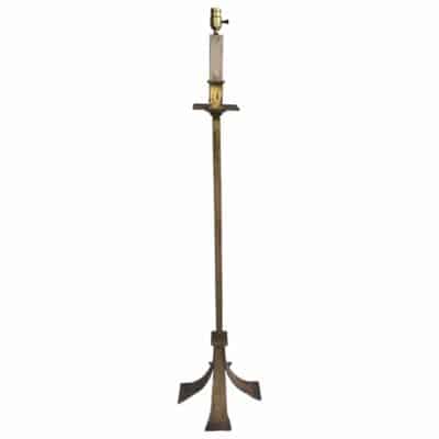 Antique French metal candle stick lamp with hammered gilded finish featuring four extended tapered feet presented in a side view against a