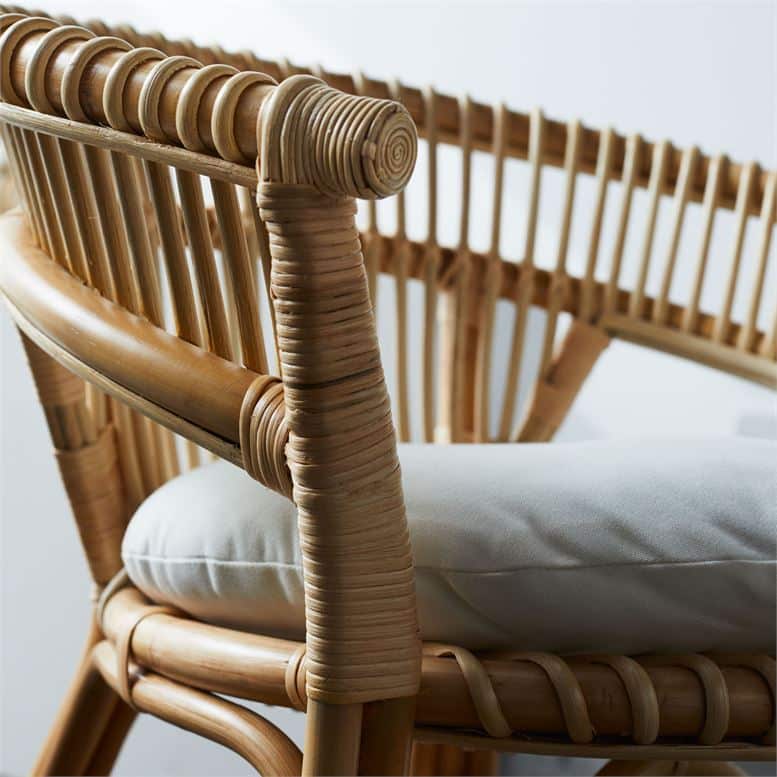 The image displays a woven dining chair with a bamboo frame featuring a barrel back design It has a double-rail backrest with