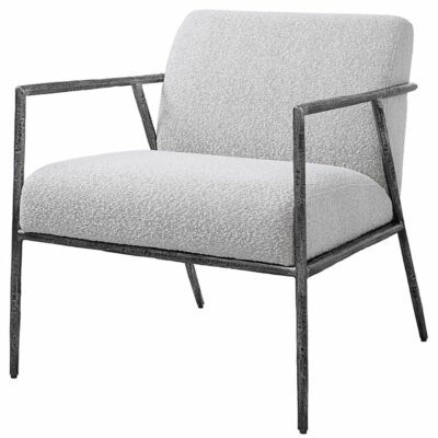 Modern armchair with cast iron frame, upholstered in warm gray boucle fabric.