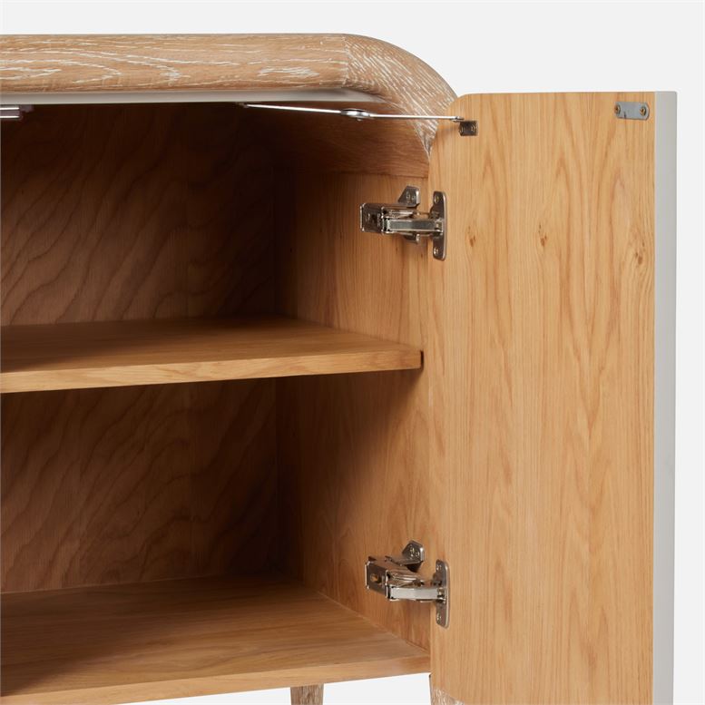 A wooden sideboard cabinet with pull handles available in three finishes French gray off-white and pristine The image shows the open door