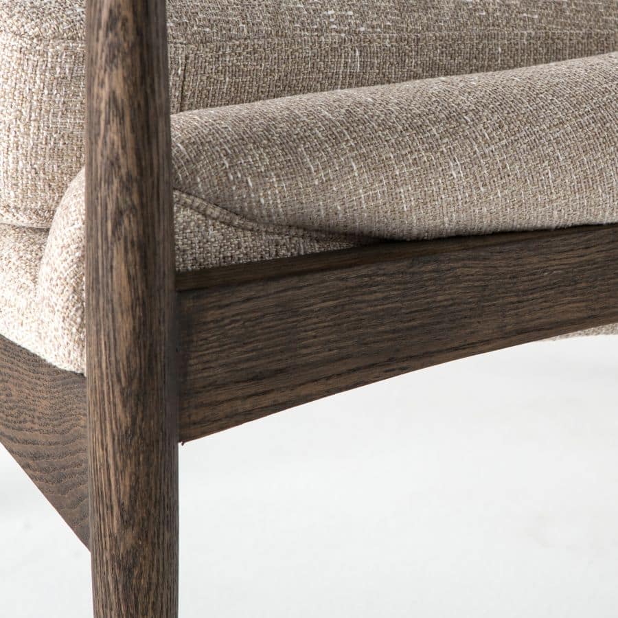 Brown lounge armchair with light camel upholstery, set against a light background.