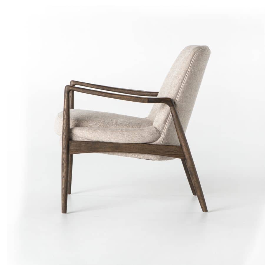 A modern armchair with light camel upholstery and warm nettlewood oak frame, showcasing a minimalist design against a white background.