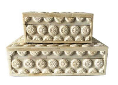 A set of two decorative bone boxes featuring a grommet design, with one larger and one smaller, displayed against a white background.