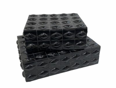 A stack of large and small black bubble bone boxes, each with a grid-like pattern on their surface.