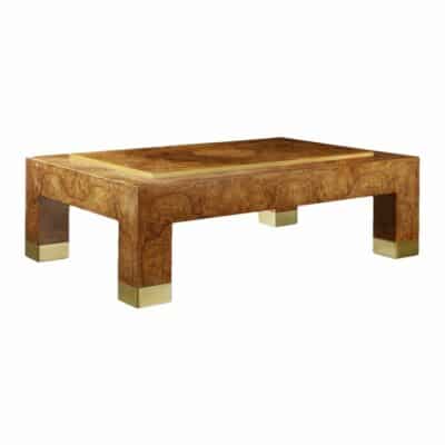 A sleek, modern coffee table featuring an olive ash burl top with brass accents on a raised center panel.