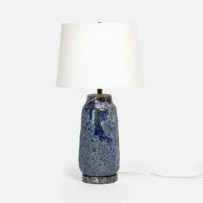 Table lamp with a unique tall design inspired by pottery artistry The lampshade features a blue or brown reactive ceramic texture that