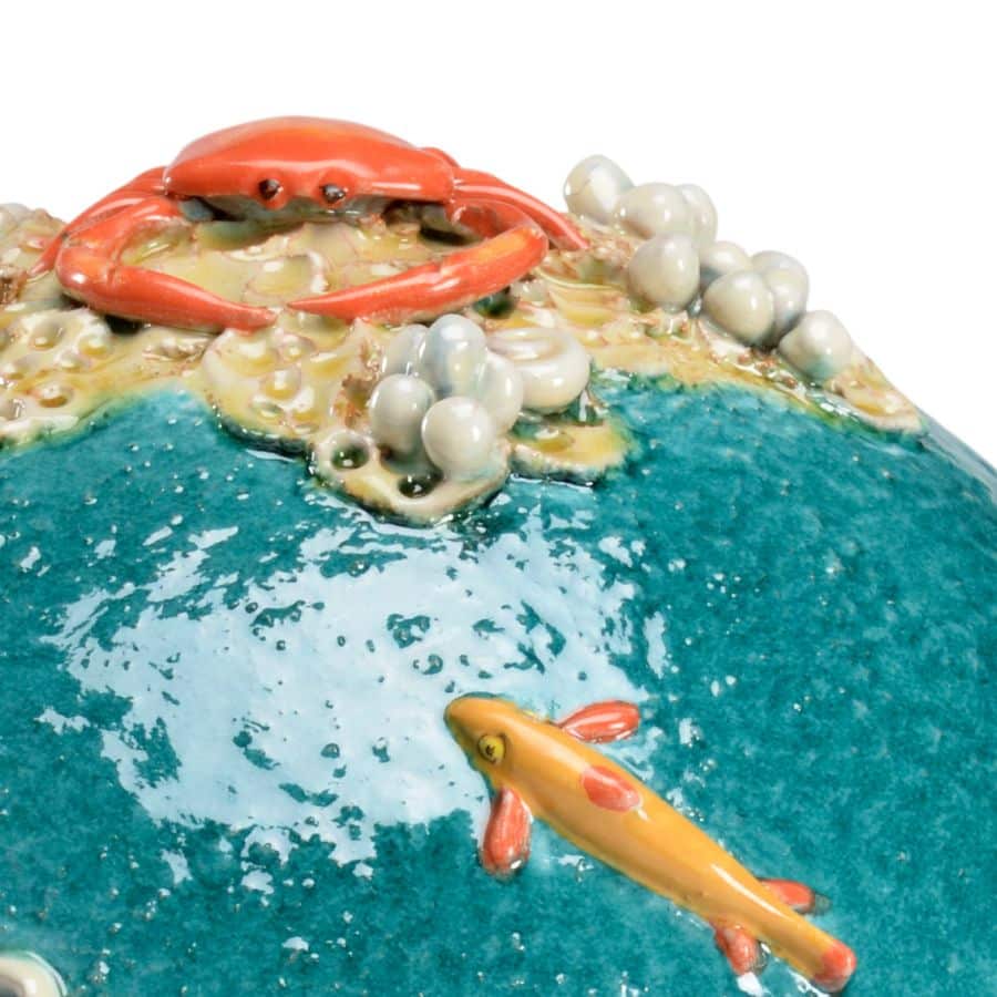 Handcrafted ceramic sea sphere sculpture, featuring vibrant blue ocean waves, realistic red crab, pearls, coral, and fish.