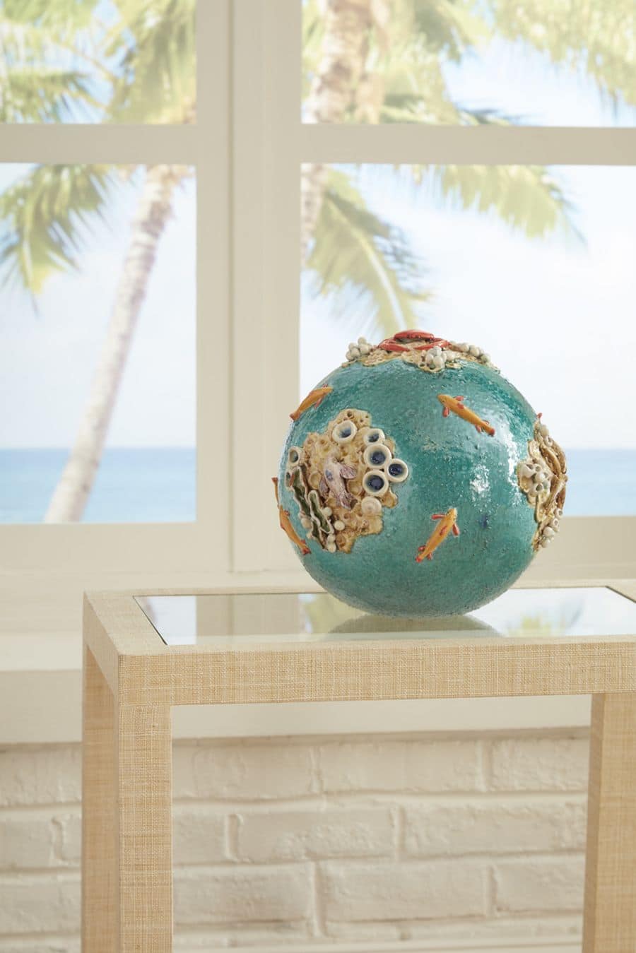 Handcrafted ceramic sea sphere in a vibrant shade of turquoise, featuring a unique design with fish and coral accents.