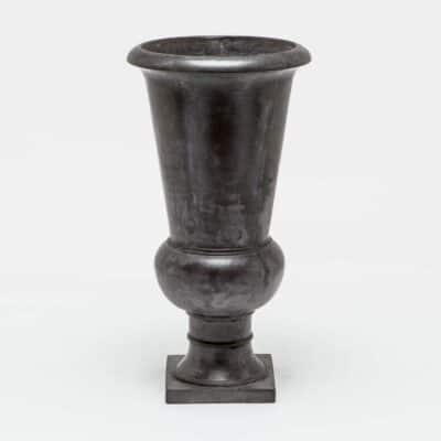 Large, decorative black vase sitting on a white surface.