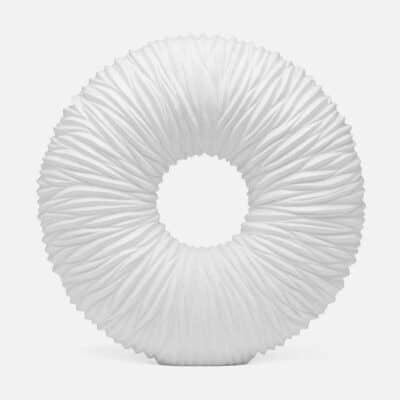 White cast stone garden sculpture with ridged texture, round shape, and resembling a tire.