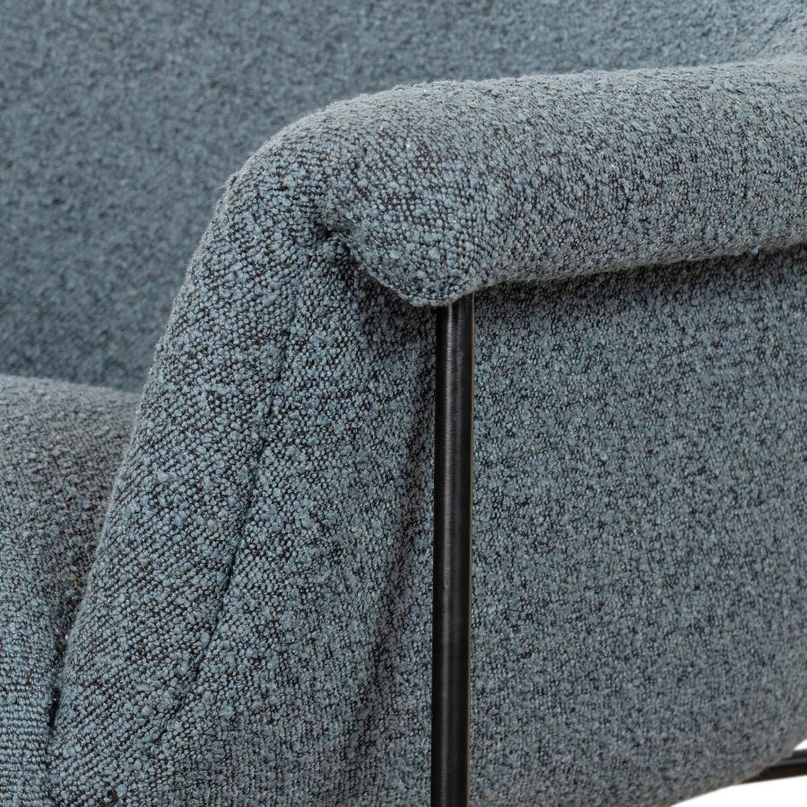 A gray mid-century style boucle chair, showcasing its plush texture and sturdy black metal base.