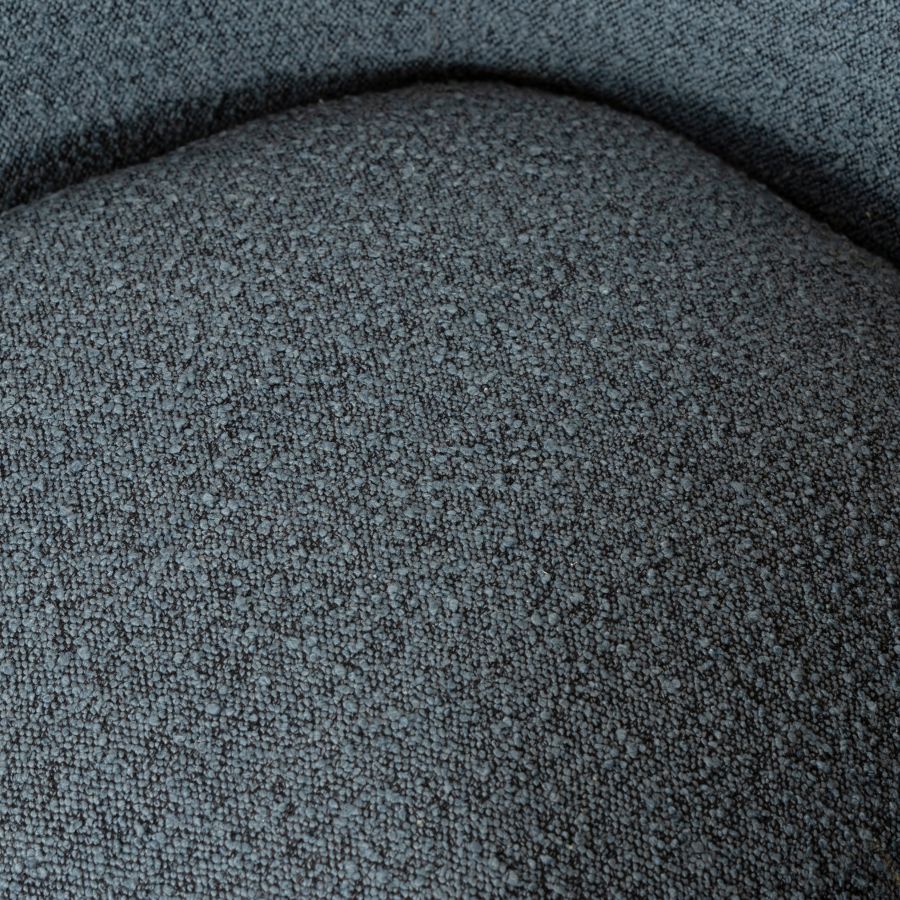 Close-up image of a mid-century style boucle chair, showcasing its gray fabric upholstery with visible texture and pattern.
