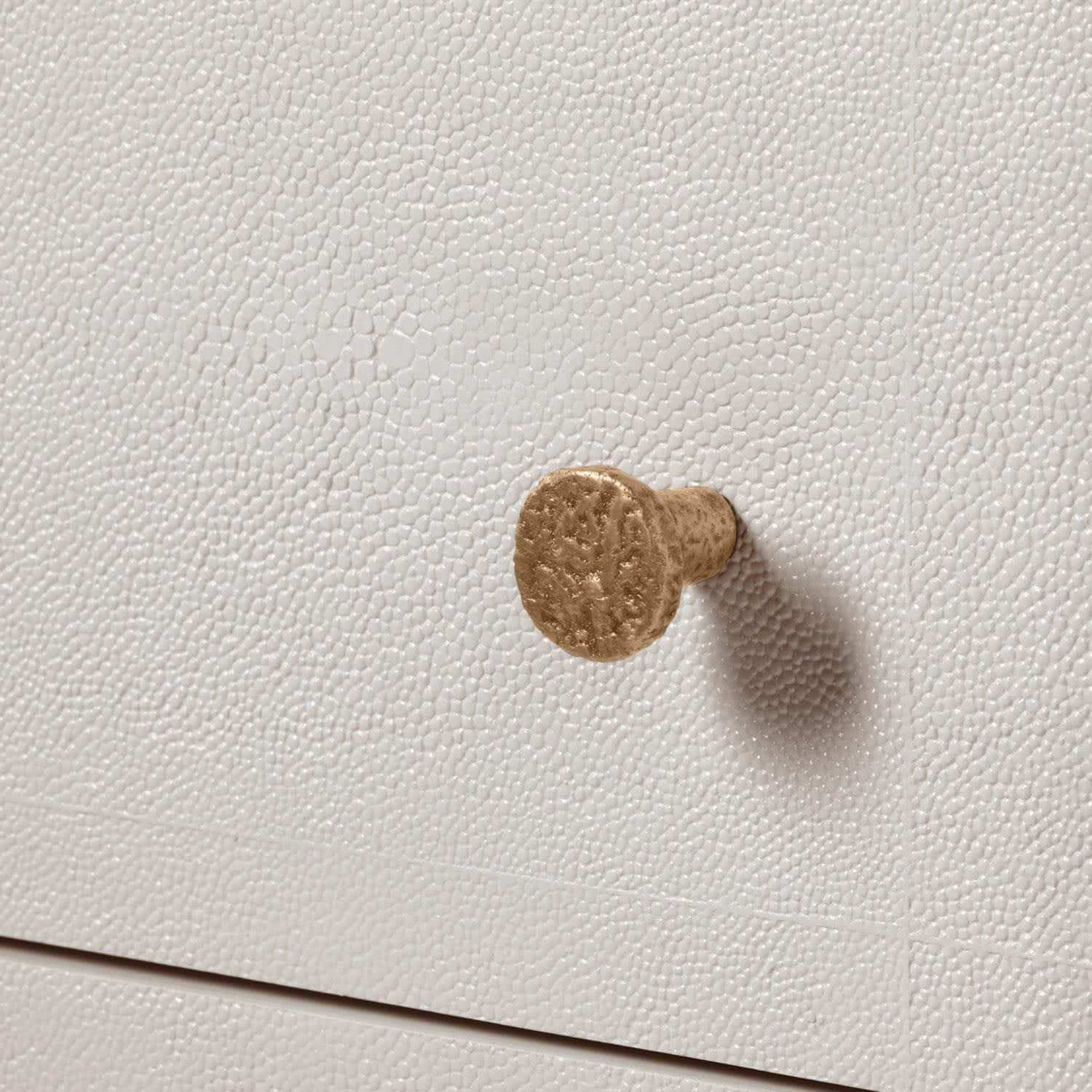 Small, elegant Carri Faux Shagreen dresser with a gold-toned knob peeking out from behind a white surface.