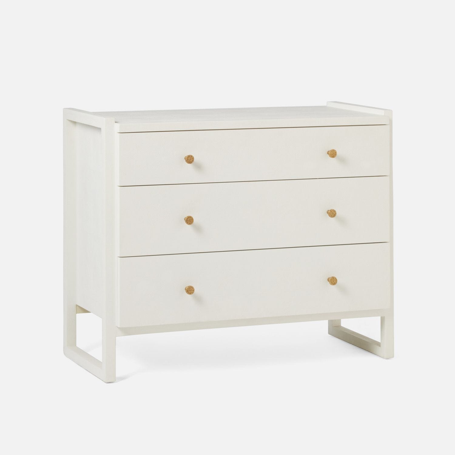Small, white Carri Faux Shagreen Dresser with three drawers, each adorned with brass handles.