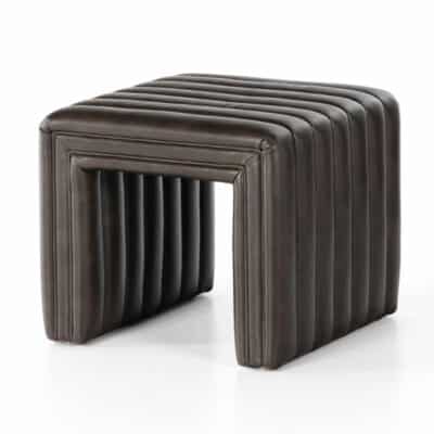 Contemporary leather ottoman in a rich brown color, featuring a unique channel design, positioned against a neutral background.