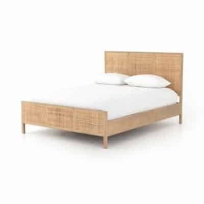 A light brown wicker bed frame in a minimalist setting.