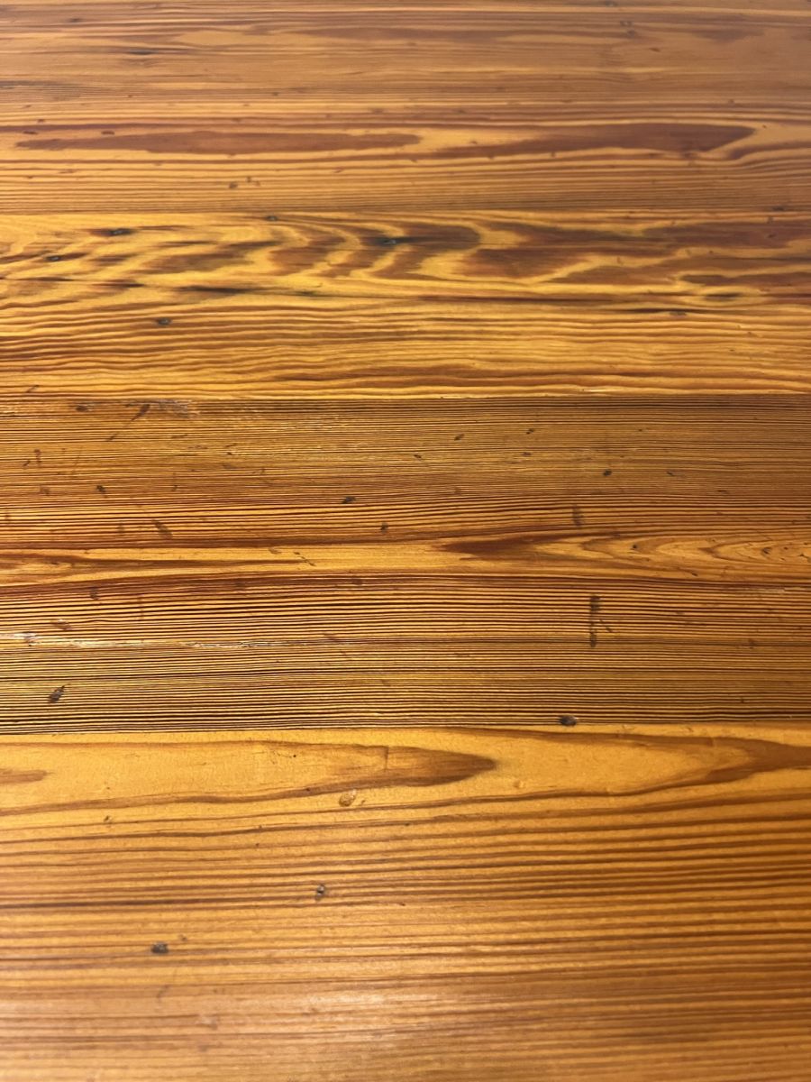 Custom French farm style dining table with reclaimed pondersa pine boards, featuring a distressed fruitwood finish that highlights exquisite grain details.