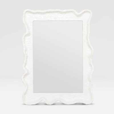 Textured white plaster resin mirror with undulating frame and glossy finish, set against a neutral background.
