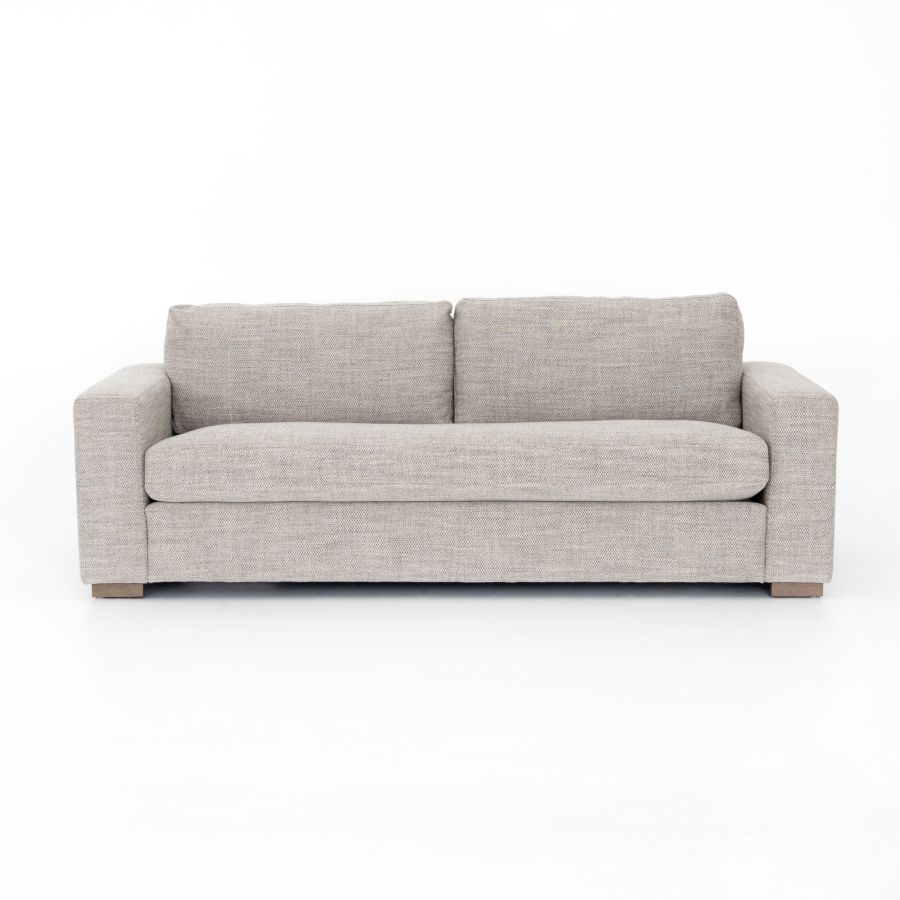 Modern grey upholstered sofa on display in a store.
