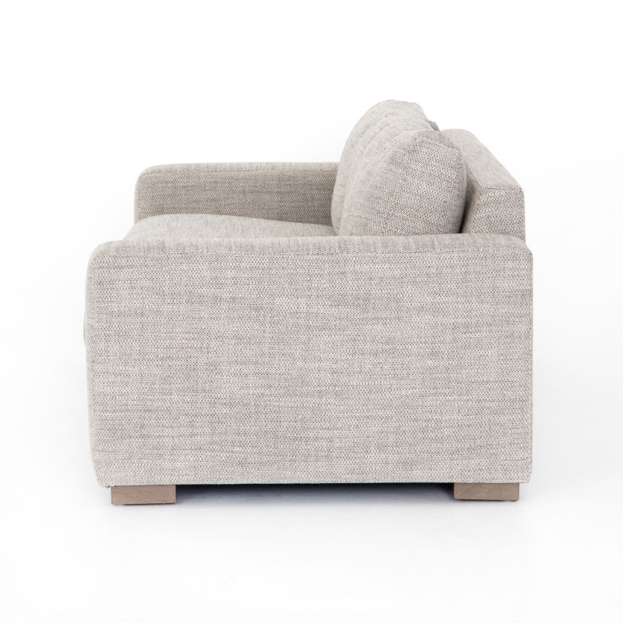 A modern block sofa in a cream color with a wooden base, available for purchase.