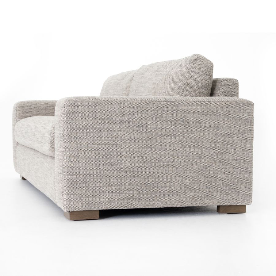 A cream colored modern block sofa in a showroom setting.