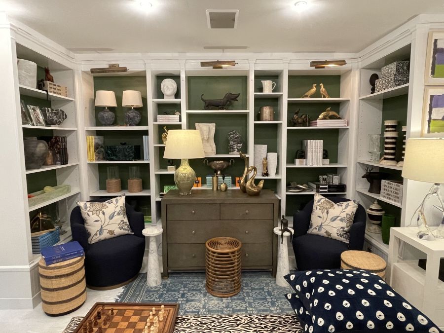 A cozy corner featuring the Joel Striped Rattan Stool in weathered brown, paired with a plush blue cushion.