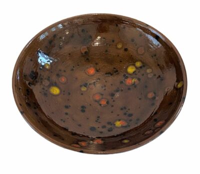 Close-up of vintage glazed ceramic bowl with brown tones and speckled design.