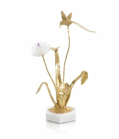Gold hummingbird sculpture on quartz base.