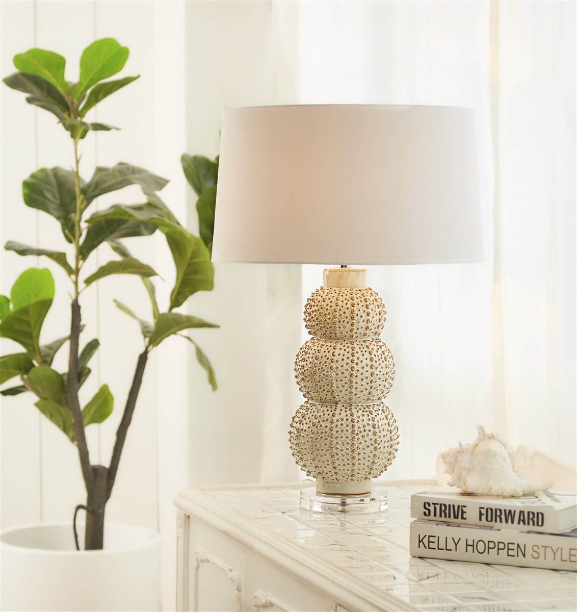 Sea Urchin Cream Table Lamp in white cotton shade, front view on wooden table.