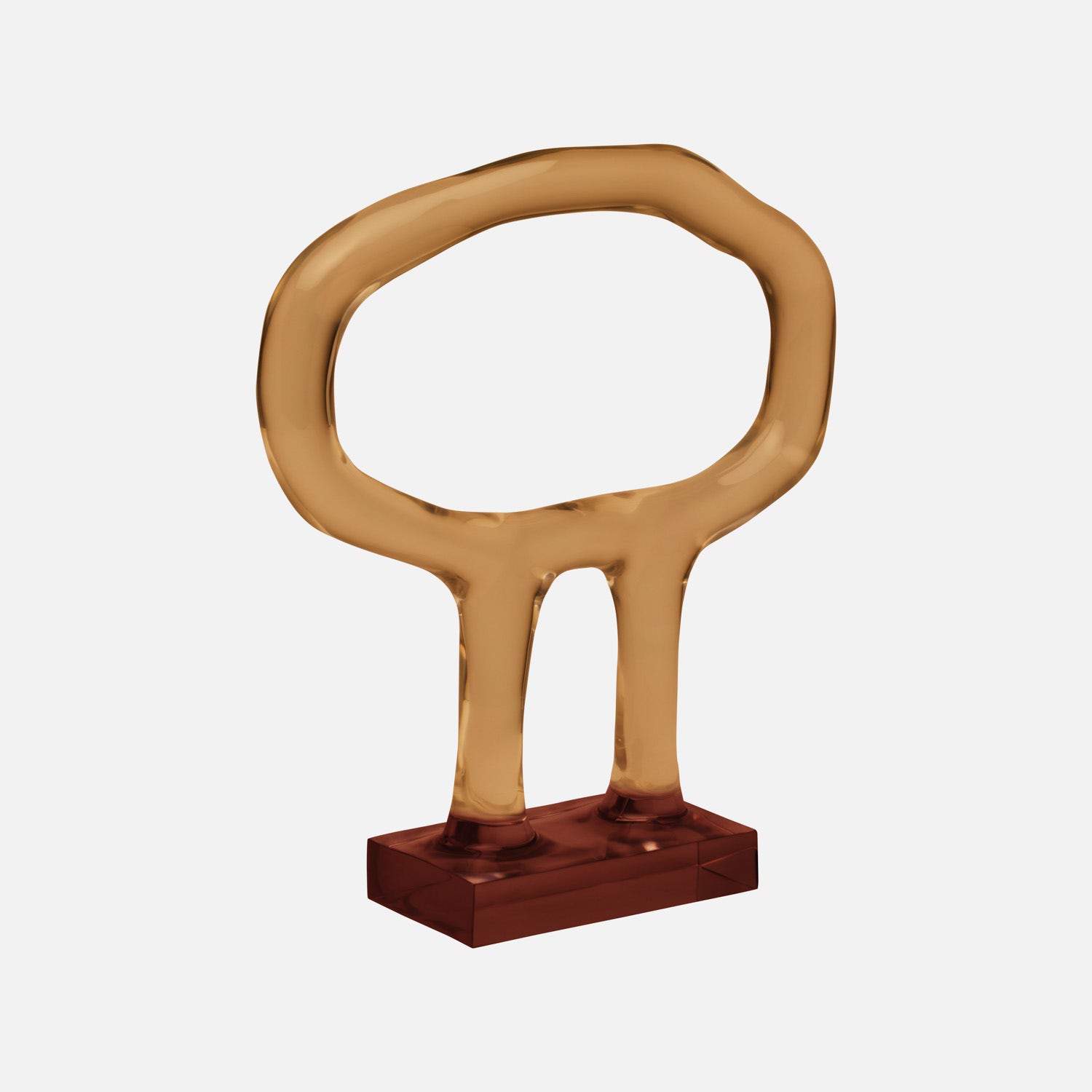 Gold-tone translucent resin sculpture, circular form on red base.