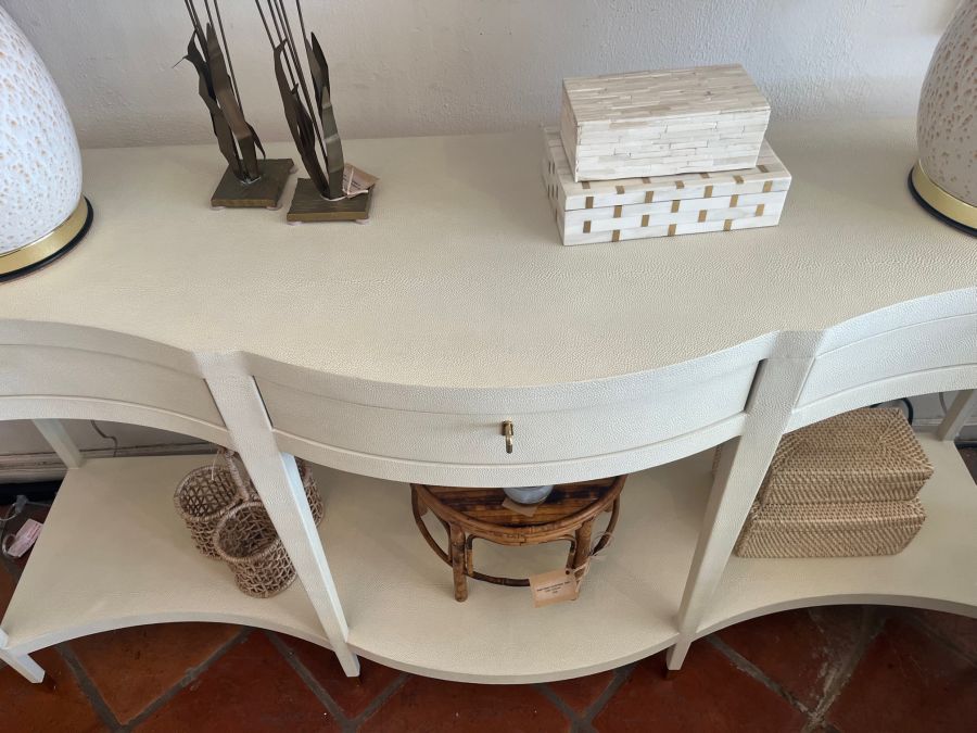 Ivory faux shagreen console with brass-finished keyhole hardware, tapered legs, and satin brass ferrules. Serpentine front.