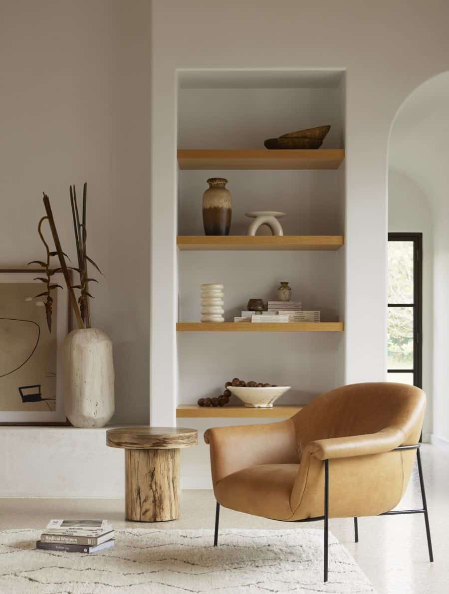 Stylish mid-century leather chair in nude color, featuring a black iron base and available in both butterscotch and boucle options.