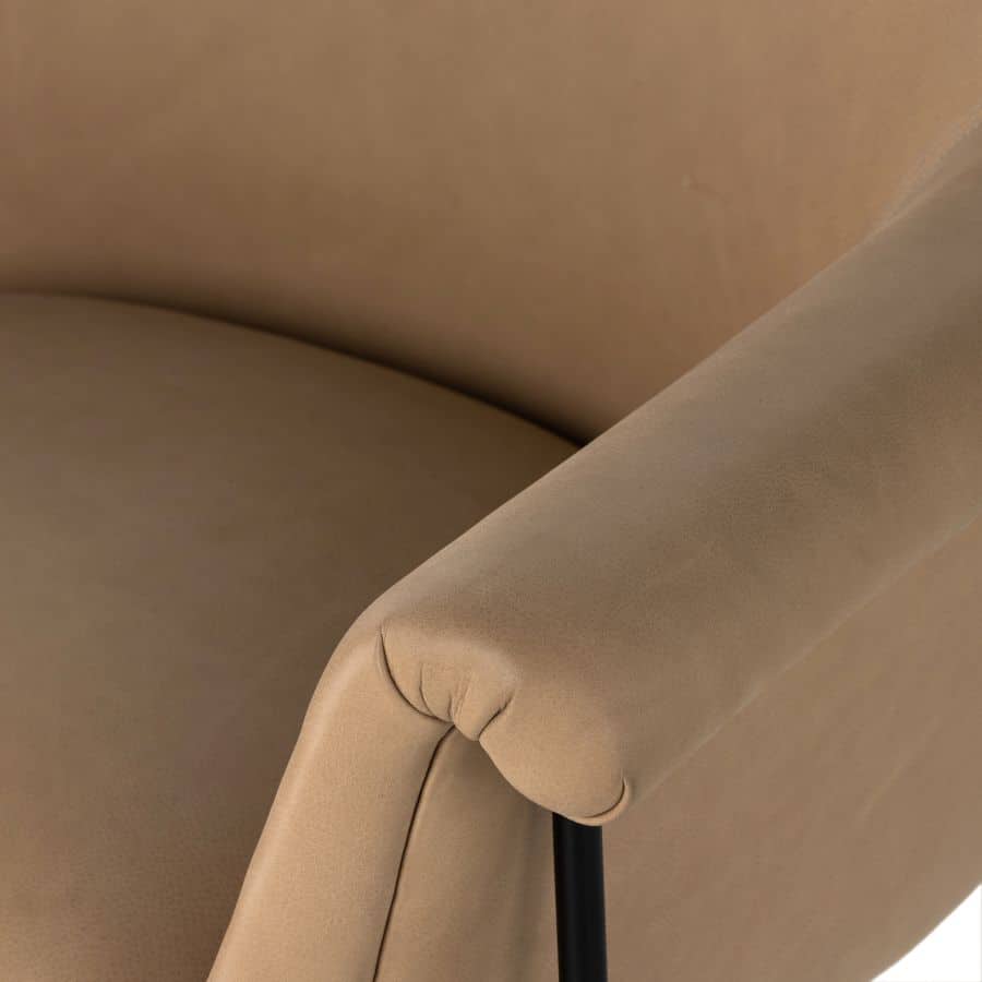Close-up of butterscotch leather mid-century style chair with black iron base.