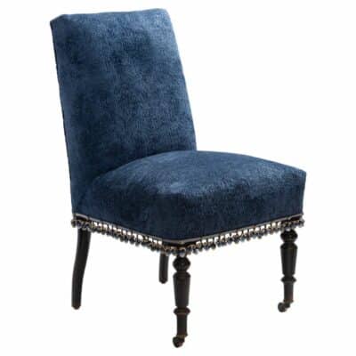 Front view of antique French navy slipper chair with ribbon and ball fringe in velvet upholstery.